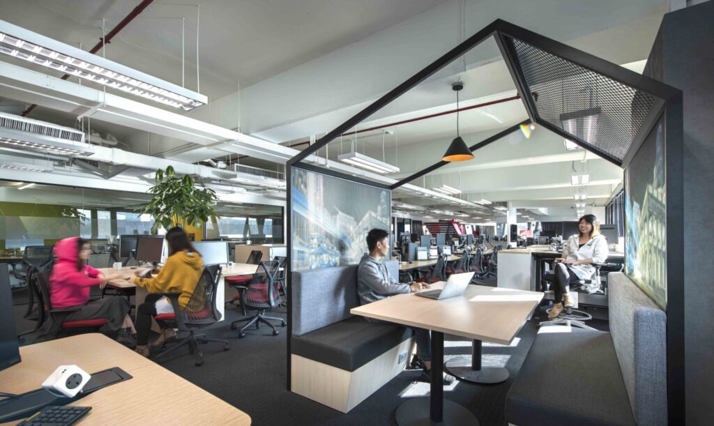 Escritório moderno utilizando as soluções de gestão de espaço. Profissionais modernos e elegantes trabalhando de forma calma e produtiva.